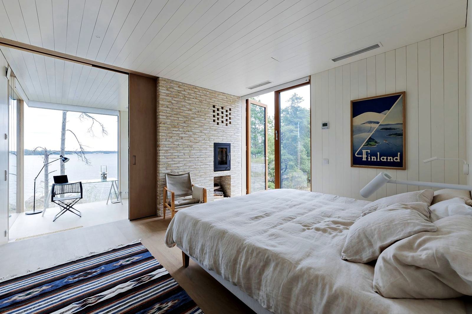 A double bed in linen, a study by the window and the sea beyond